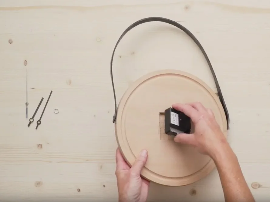 Person baut Uhr zusammen