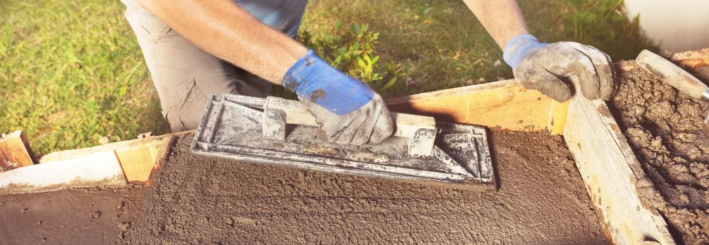 Person glättet Beton mit Kelle