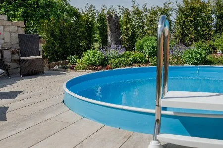 Blauer Stahlwandpool mit Leiter im Garten