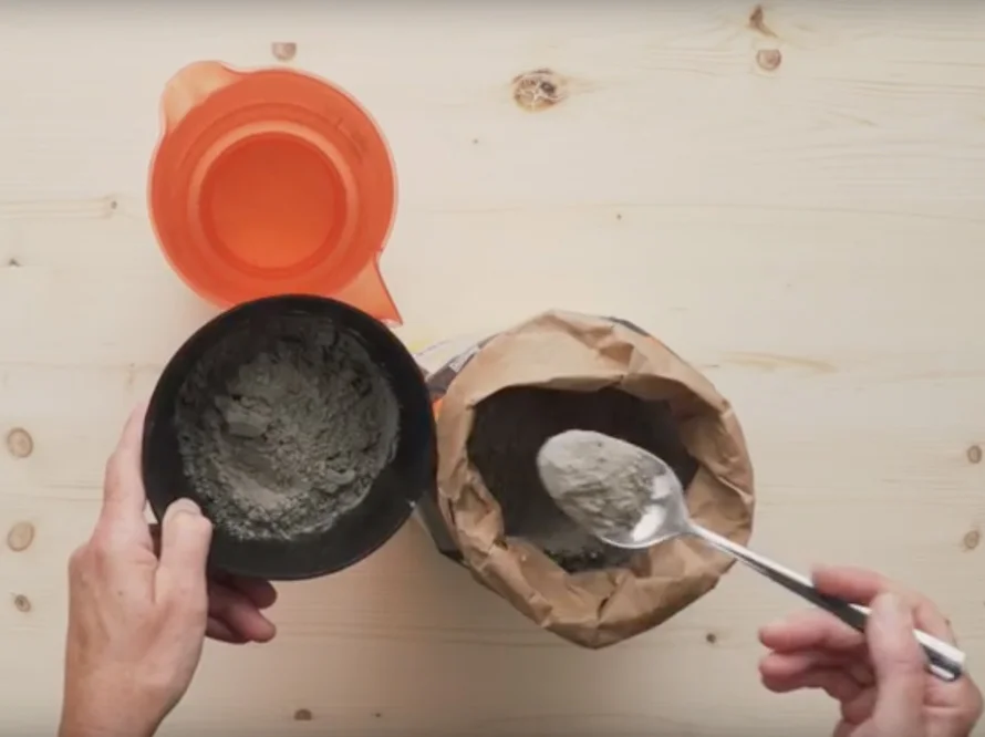 Zement wird mit einem Löffel portioniert.