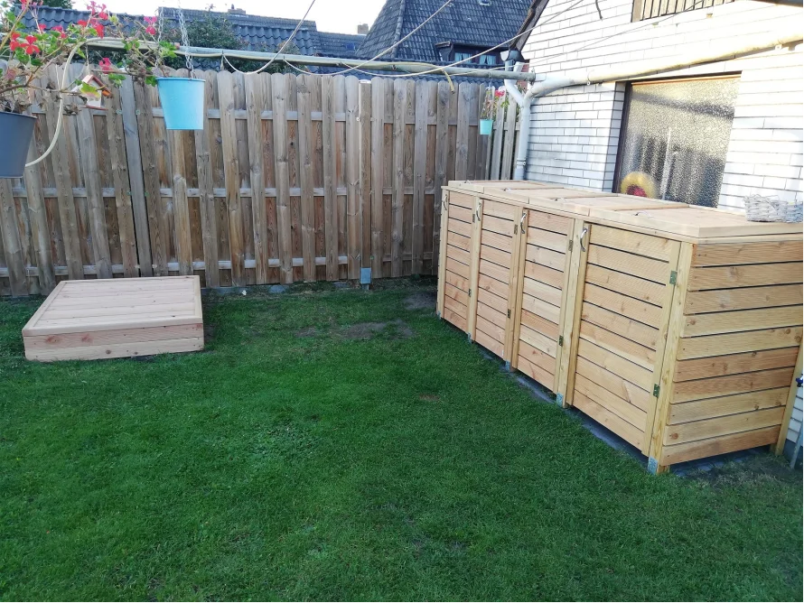 Garten mit Holzmülltonnenverkleidung und Sandkasten
