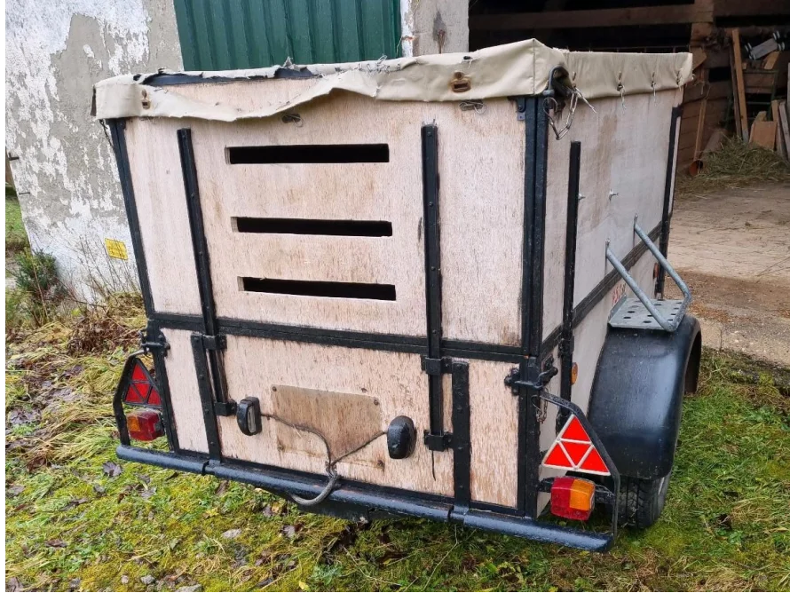 Ein kleiner offener Tieranhänger mit Plane.