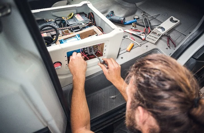 Person verlegt Kabel mit Schraubendreher