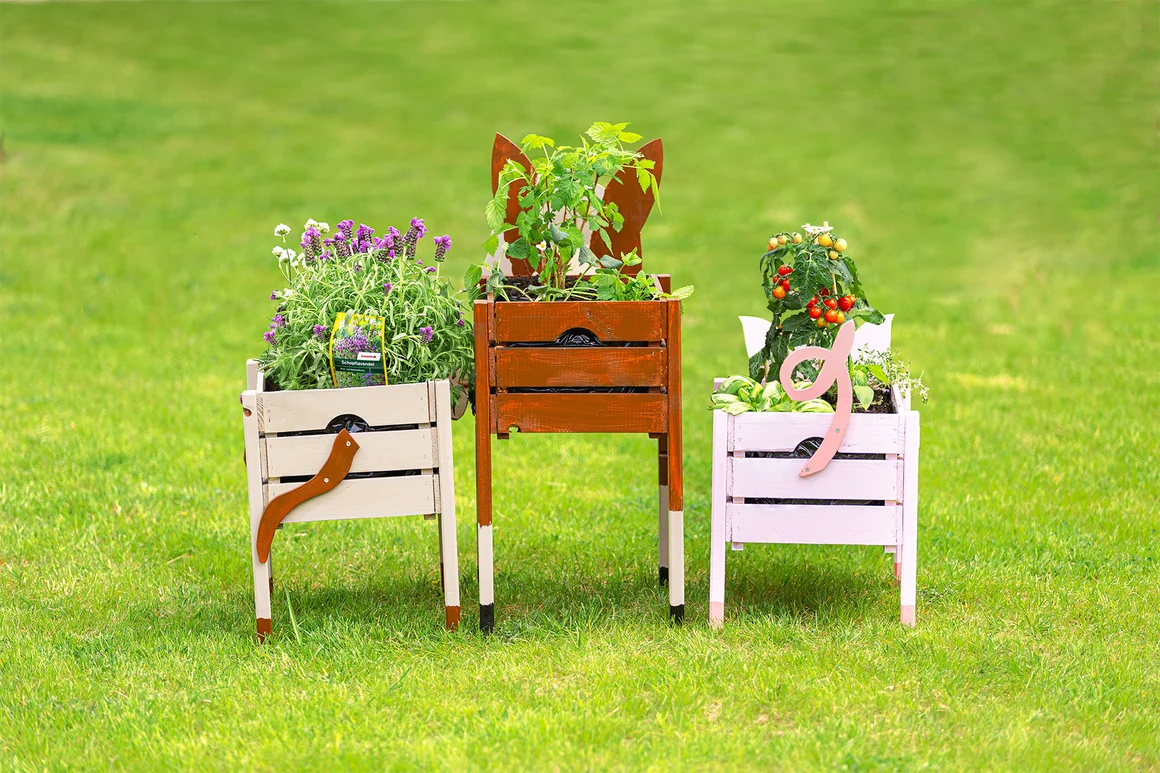 Drei bunte Hochbeete in Tier-Optik auf einer grünen Wiese.