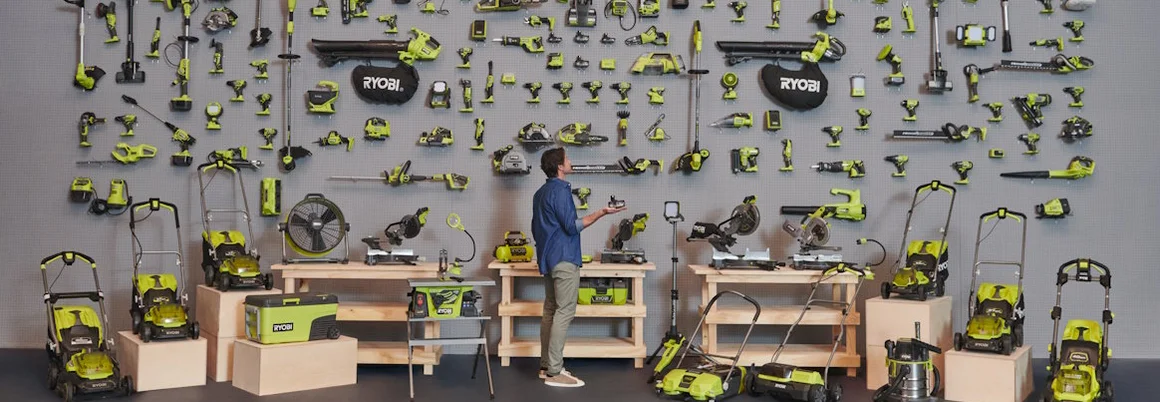 Person mit vielen Gartengeräten