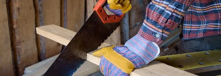 Person sägt Holz mit Säge