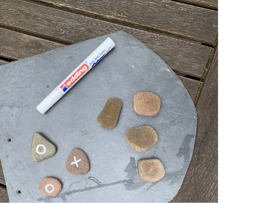 Schiefertafel mit Steinen und Stift