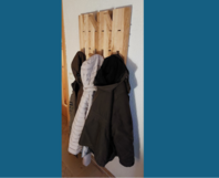 Garderobe aus Holz mit Jacken