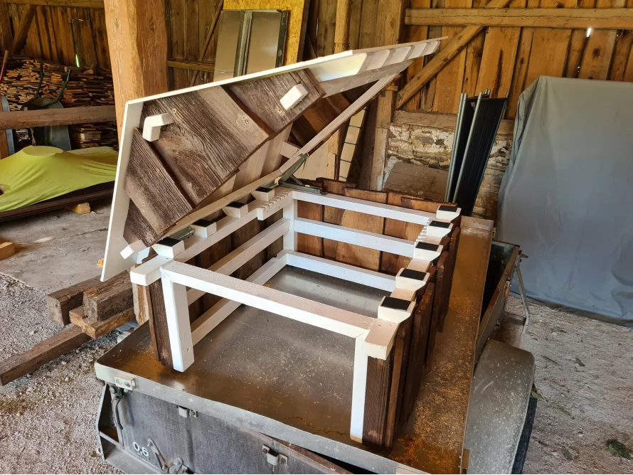 Eine Garage für einen Mähroboter im Design eines Gartenhauses