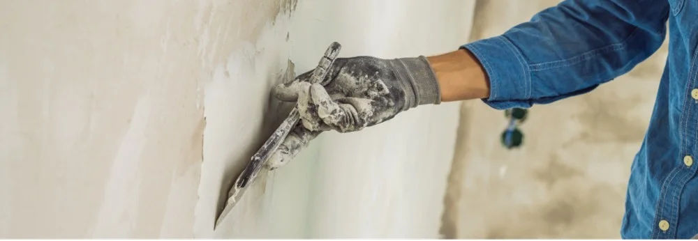 Person verspachtelt Wand