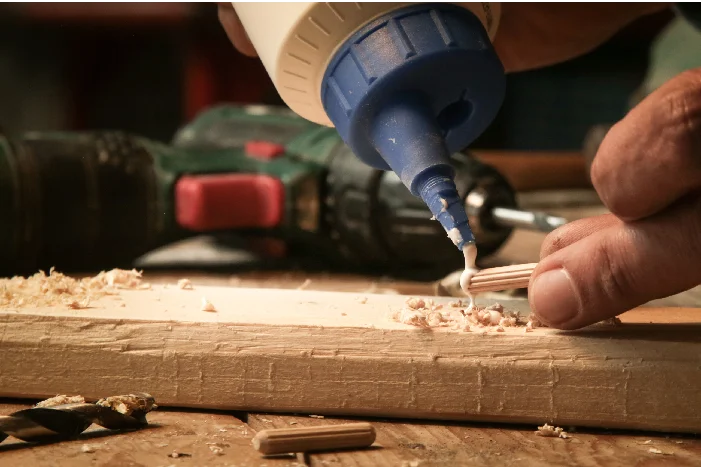 Person baut ein Gartenhaus aus Holz