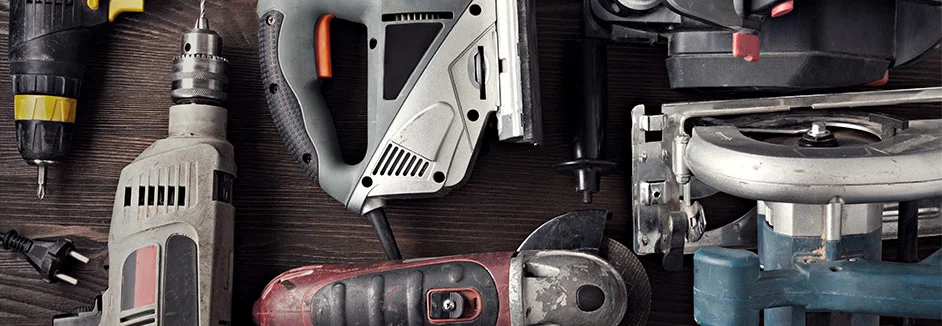 Verschiedene Elektrowerkzeuge auf Holztisch.