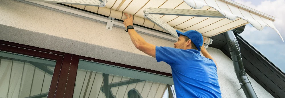 Person montiert Markise