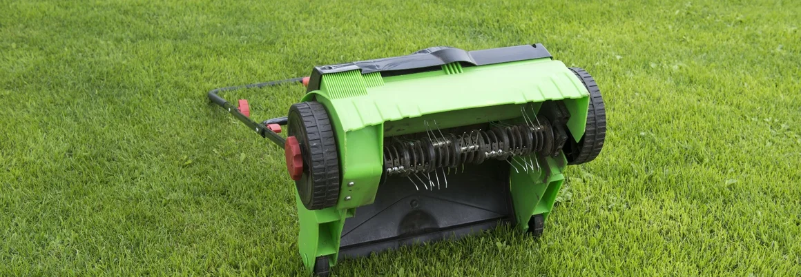 Vertikutierer auf grünem Rasen