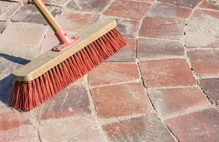 Besen reinigt Pflastersteine