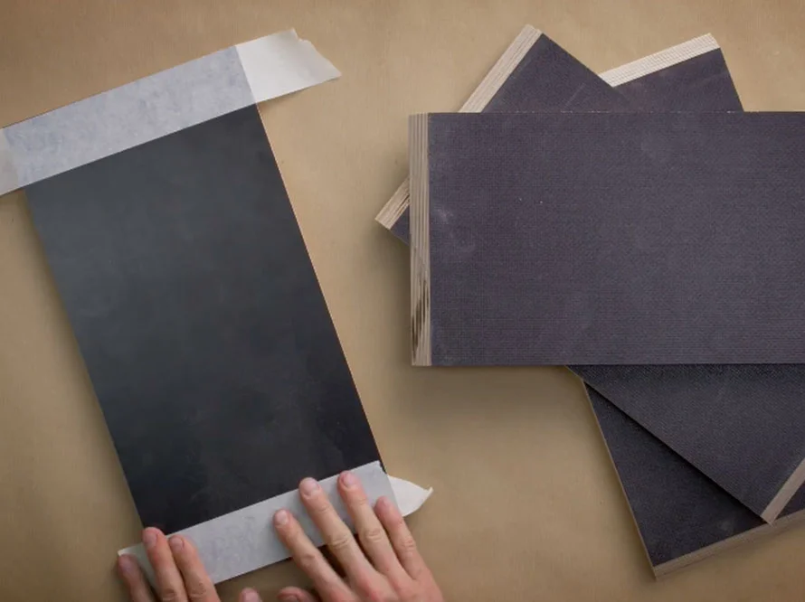 Person klebt Holzplatten mit Klebeband ab