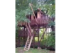 Ein Baumhaus aus Holz mit einer Leiter und einem Flaschenzug.