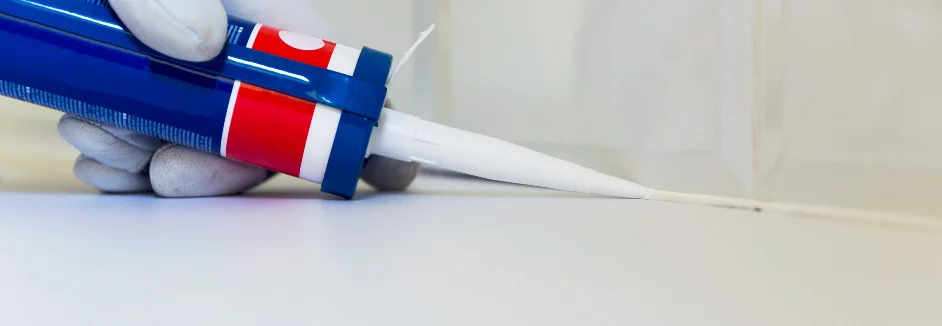 Hand mit Kartuschenpistole versiegelt Fuge