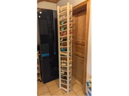 Hoher, schmaler Weinregal aus Holz mit Weinflaschen