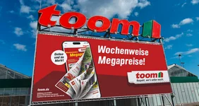 Bild eines toom Baumarktes mit einer große Werbetafel vor blauem Himmel.