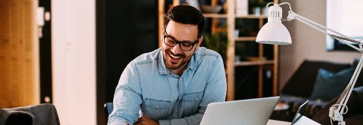 Person lächelt und schreibt in ein Notizbuch