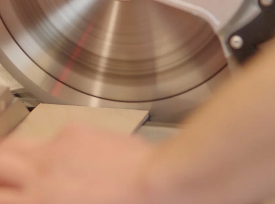 Hand führt Holz an Kreissäge