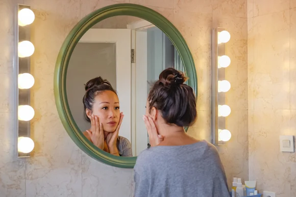 Person betrachtet sich im Spiegel