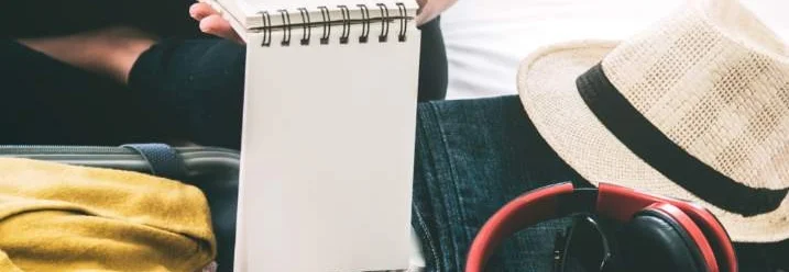 Person schreibt mit Bleistift auf Notizblock