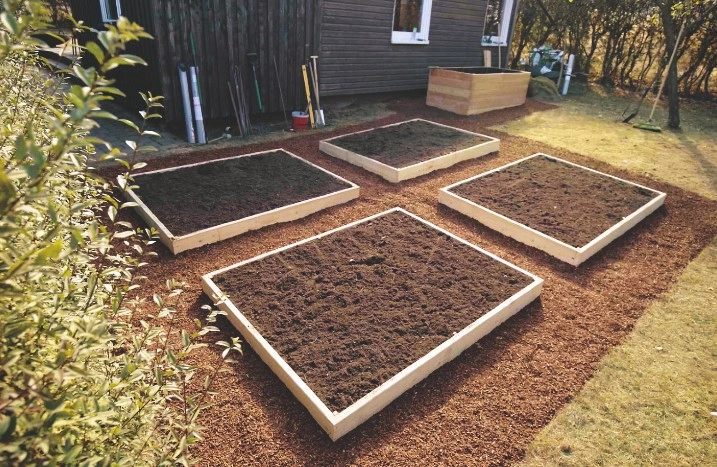 Vier Hochbeete gefüllt mit Erde