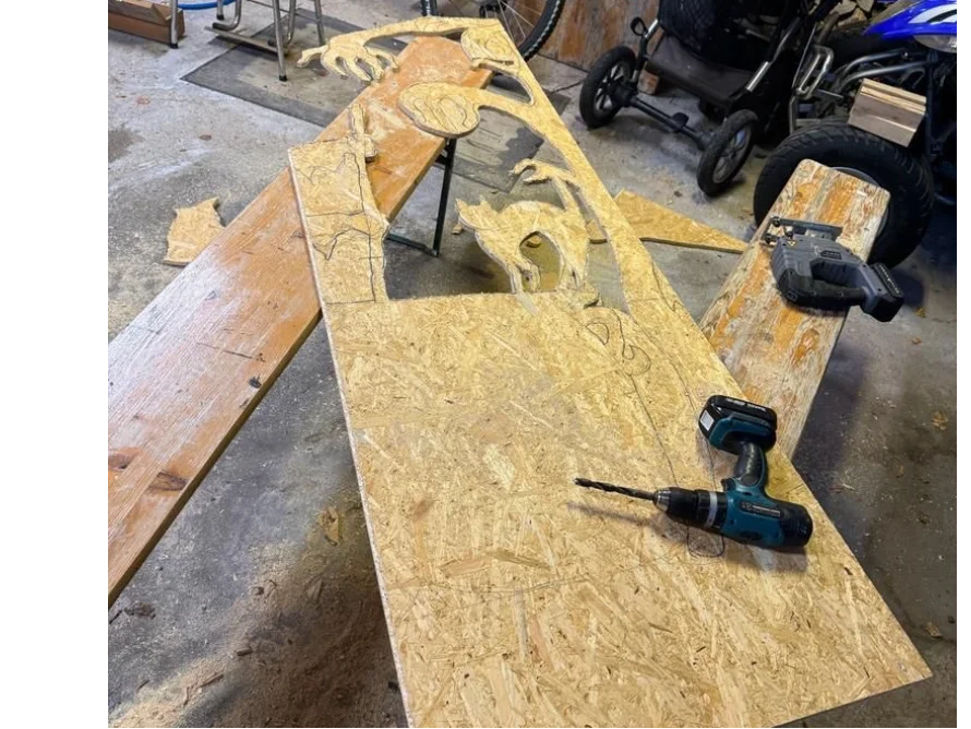 Holzplatte mit aufgezeichnetem und ausgeschnittenem Muster und einem Akkuschrauber