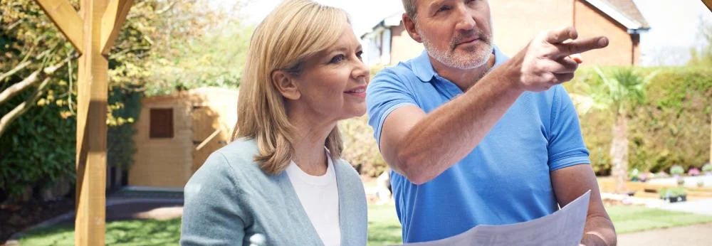 Zwei Personen besprechen einen Bauplan für den Garten.