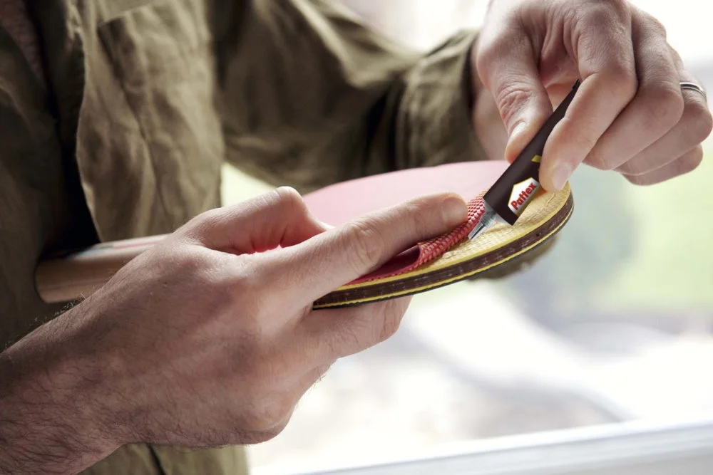 Person klebt Tischtennisschläger