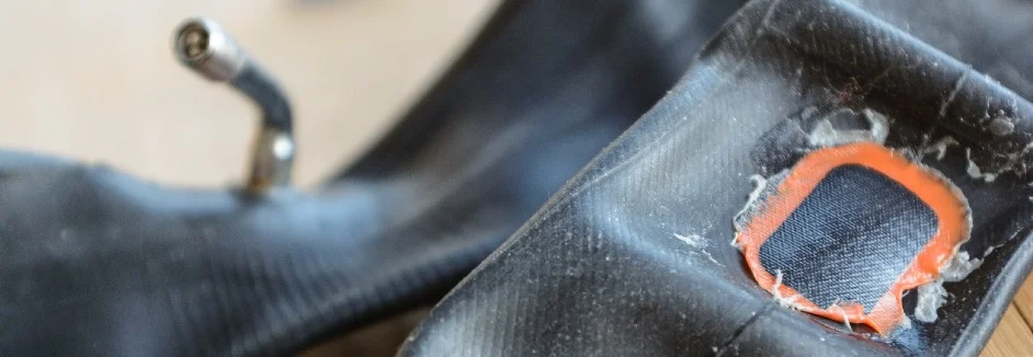 Geflickter Fahrradschlauch mit einem orangen Flicken.