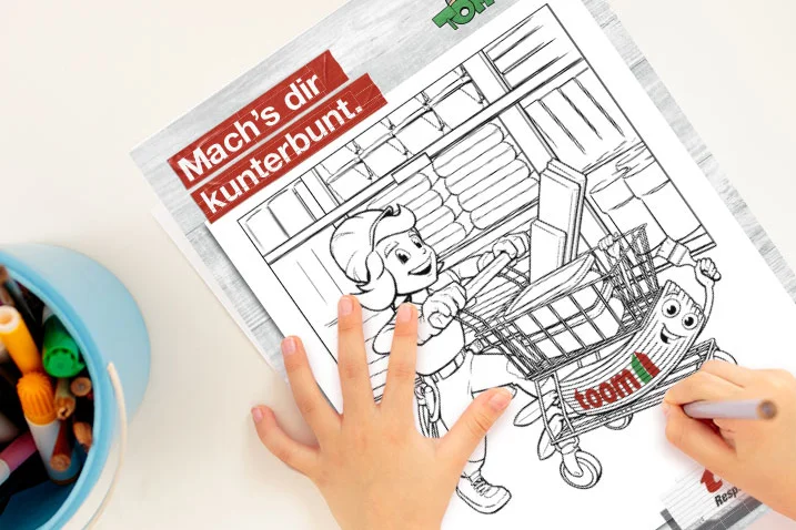 Kind malt ein Ausmalbild mit Buntstiften.