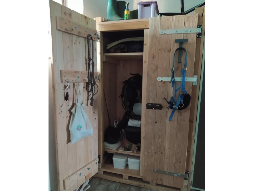 Offener Holzschrank mit Reitzubehör