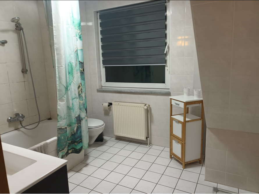 Helles Badezimmer mit Badewanne und Toilette