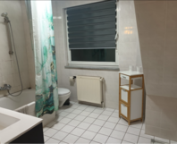 Helles Badezimmer mit Badewanne und Toilette