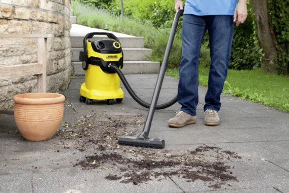 Person saugt Erde mit einem Nass-Trockensauger