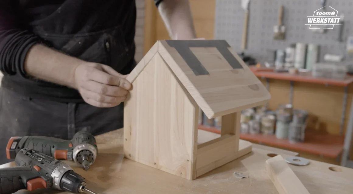 Person baut Vogelhaus