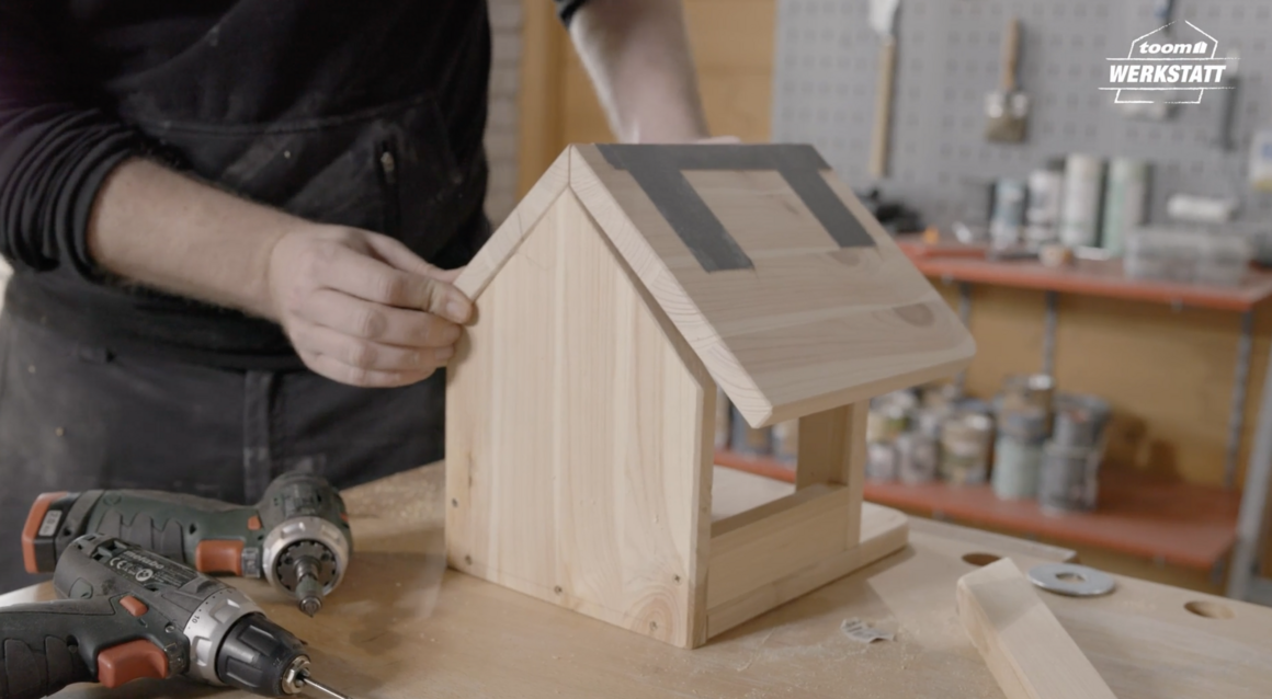 Person baut Vogelhaus