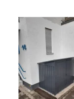 Graues Gartenhaus an Hauswand