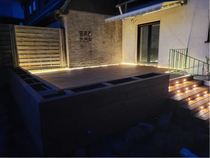 Beleuchtete Holzterrasse mit Treppe