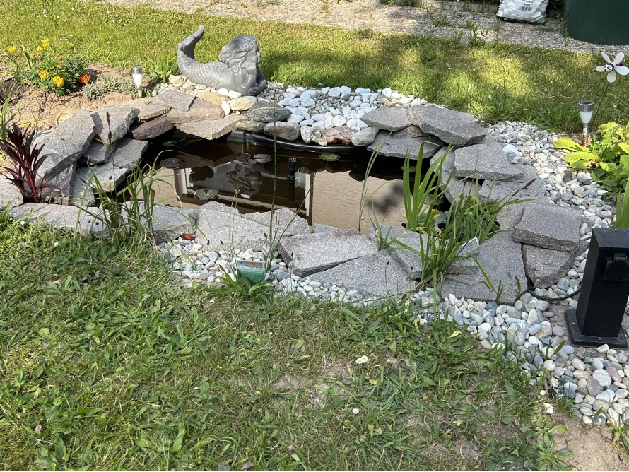 Gartenteich mit Steinrand und Meerjungfrau
