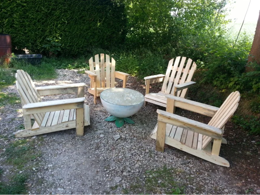 Vier Gartenstühle aus Palettenholz um eine Feuerschale