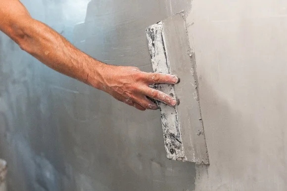 Person verputzt Wand