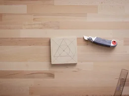 Holzplatte mit eingezeichneten Formen und Cuttermesser