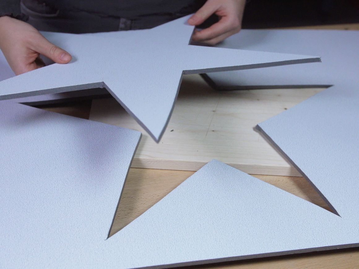 Hände schneiden einen Stern aus einer Platte