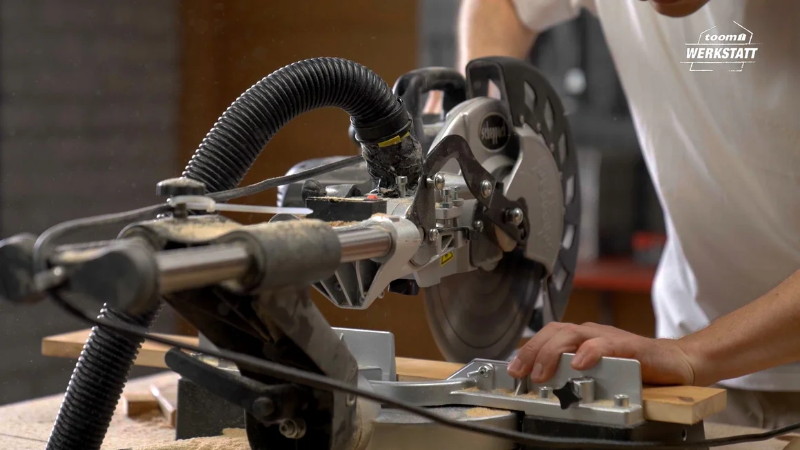 Person sägt Holz mit Kappsäge