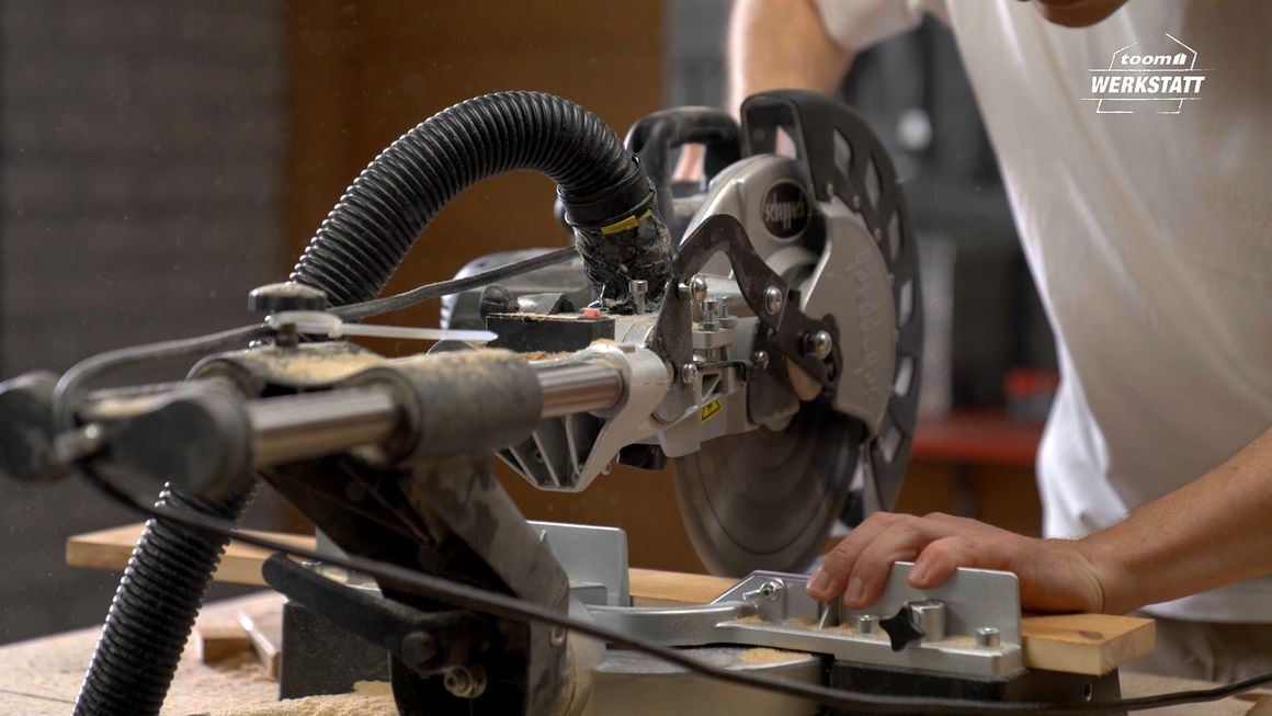 Person sägt Holz mit Kappsäge