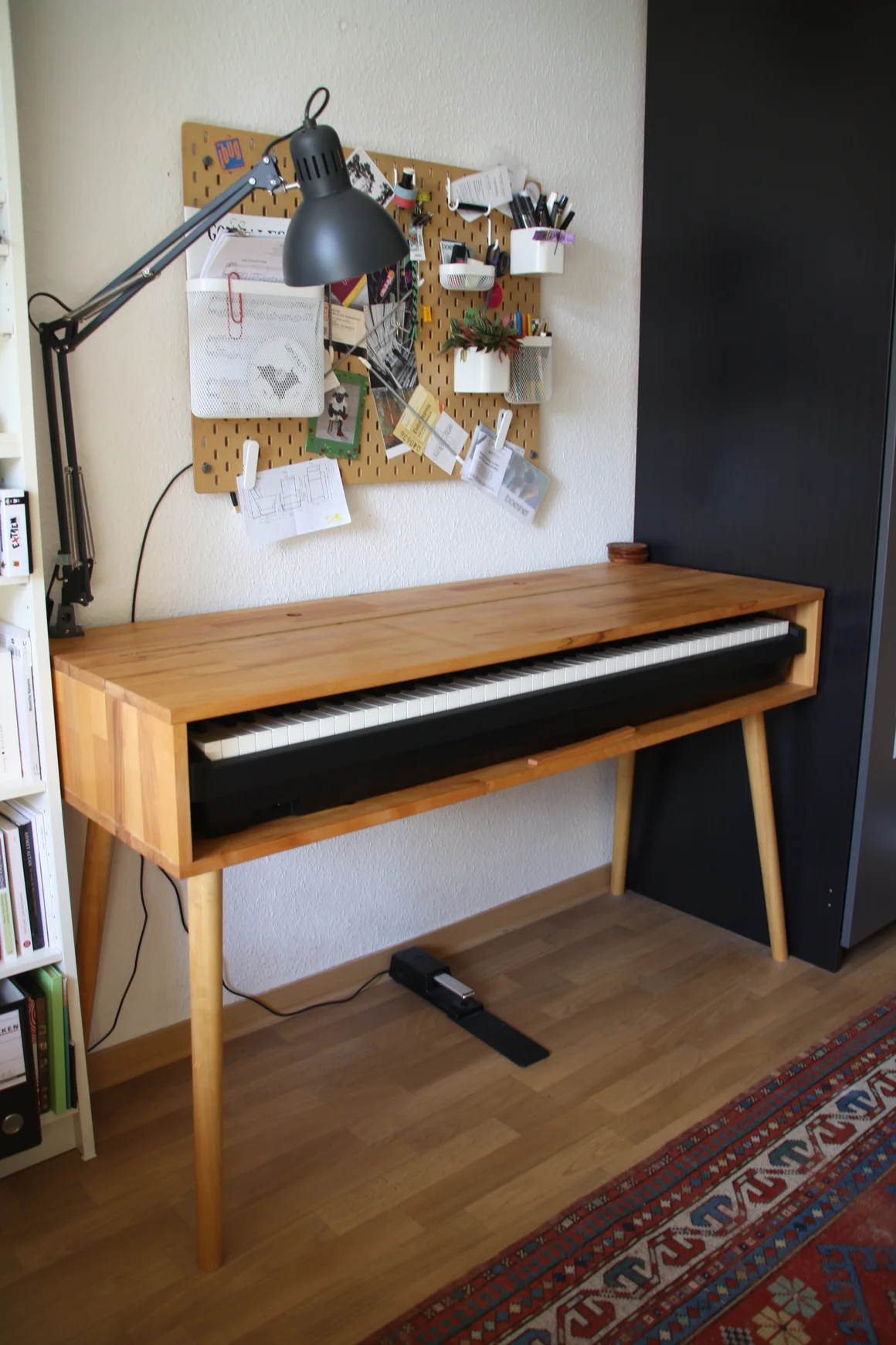 Ein E-Piano in einem Holzgehäuse in einem Arbeitszimmer.